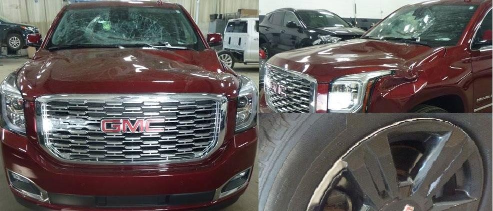Red GMC SUV with broken windshield and dents