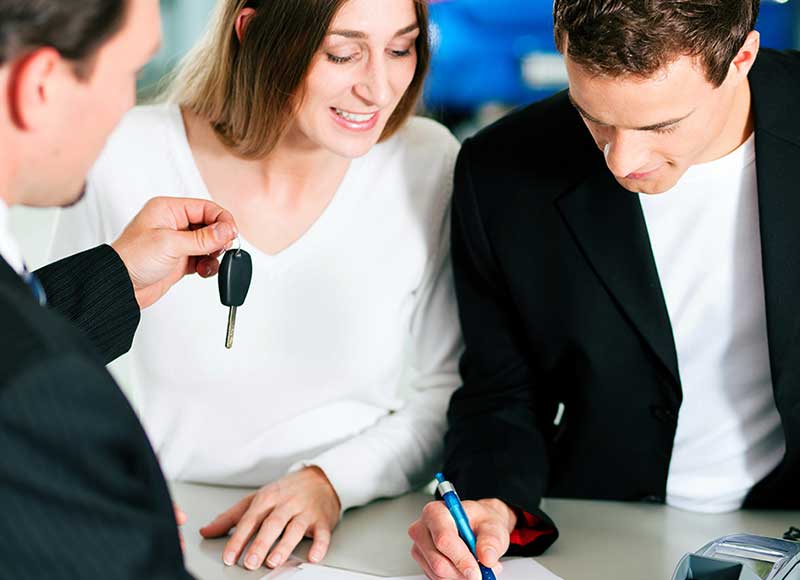 Customers signing a document to lease a car